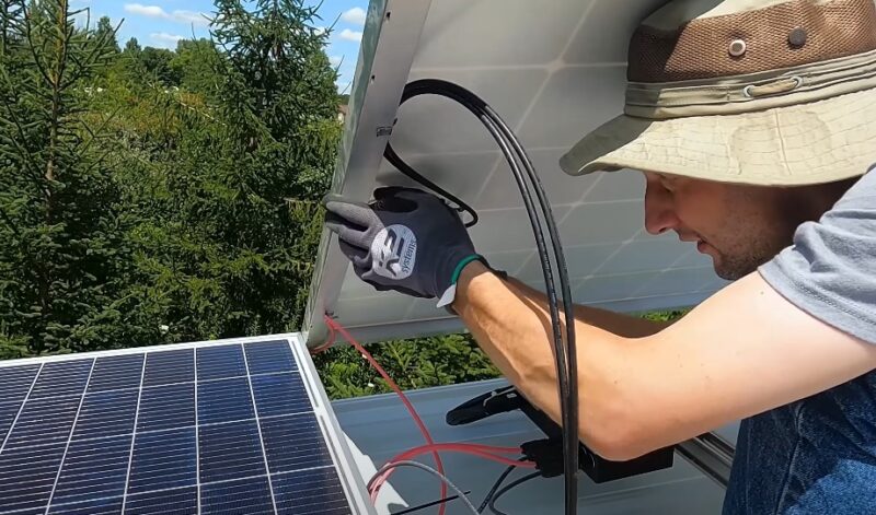 Man installing solar panels on a roof