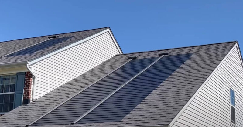 A modern home's dark gray asphalt shingles contrast beautifully with the light gray siding